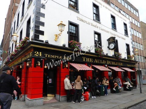 Pub The Auld Dubliner à Temple Bar, Dublin, Irlande, avec des fleurs aux fenêtres et des personnes assises à l'extérieur.
