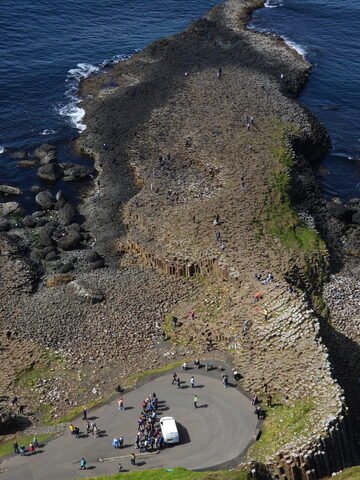 Chaussée de géants en Irlande, avec des formations rocheuses distinctives et des visiteurs sur le site.