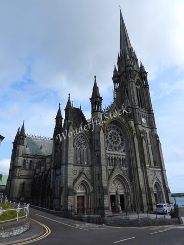 Église à Cobh, Irlande, avec une façade gothique et un grand vitrail au-dessus de l'entrée principale.