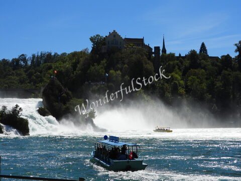 Chutes du Rhin en Suisse, avec un bateau de tourisme et une végétation luxuriante en arrière-plan.