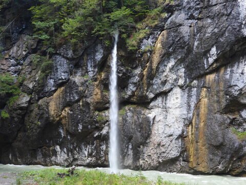 Chute d'eau dans les gorges de l'Aar, Suisse, entourée de roches et de végétation dense.