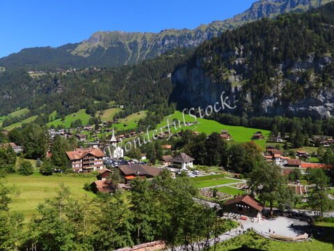 Lauterbrunnen en Suisse, avec des maisons traditionnelles, une église au centre et des montagnes en arrière-plan.