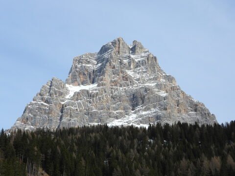 Montagne enneigée surplombant une forêt dans les Dolomites, Italie.
