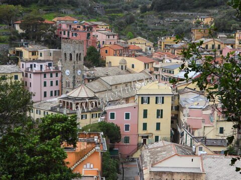 Montérosso, Italie, avec des maisons colorées et une tour avec horloge au centre du village.