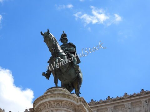 Statue équestre sur un socle à Rome, Italie, avec un ciel bleu et quelques nuages.