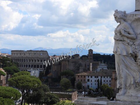 Colisée et ruines antiques à Rome, Italie, avec un ciel nuageux et des arbres verdoyants au premier plan.