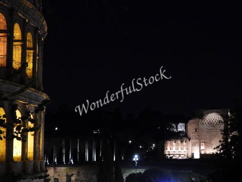 Colisée illuminé et ruines antiques à Rome, Italie, sous un ciel nocturne, avec des détails architecturaux distinctifs.