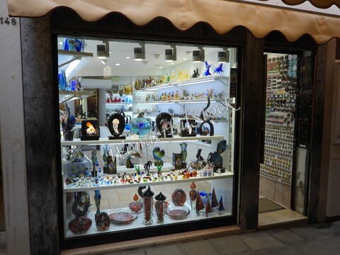 Vitrine d'une boutique de verre à Venise, Italie, exhibant des objets en verre colorés et des sculptures.