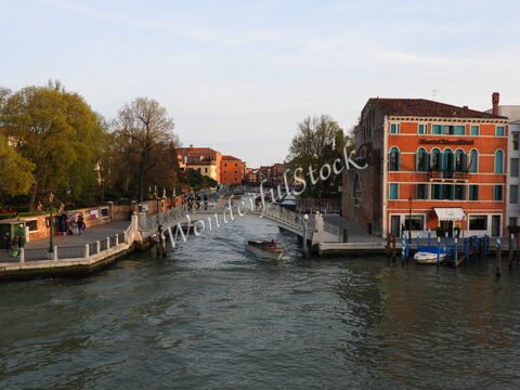 Canaux et bâtiments colorés à Venise, Italie, avec des arbres et un pont sur l'eau.