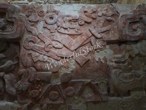 Balamku, Mexique : relief mural représentant des motifs mayas, avec des formes stylisées et des détails complexes sur un fond en pierre.