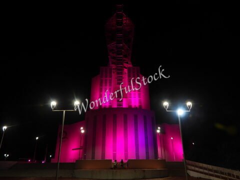 Monument illuminé en rose à Chetumal, Mexique, avec des lampadaires visibles en premier plan.