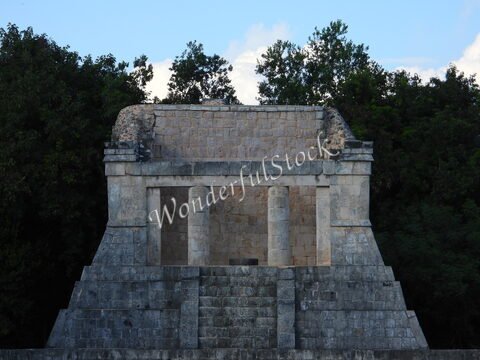Temple en pierre à Itza, Mexique, avec des colonnes et une structure pyramidale, entouré de verdure.