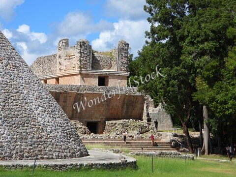 Ruines mayas et pyramide à Uxmal, Mexique, entourées d'arbres et de ciel nuageux.