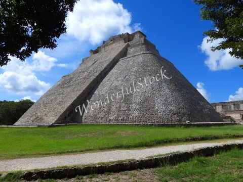 Pyramide à Uxmal, Mexique, avec des escaliers et un ciel bleu parsemé de nuages.
