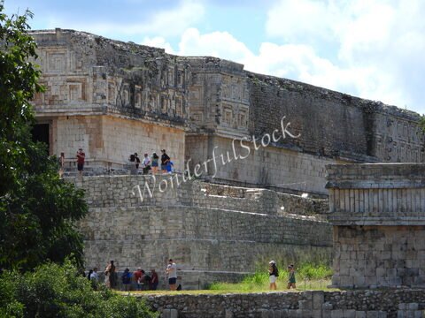 Ruines d'Uxmal au Mexique, avec des visiteurs explorant les structures en pierre et la végétation environnante.