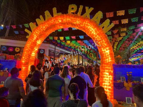 Arc illuminé avec l'inscription "Janal Pixan" entouré de décorations colorées lors d'une célébration à Cancun, Mexique.