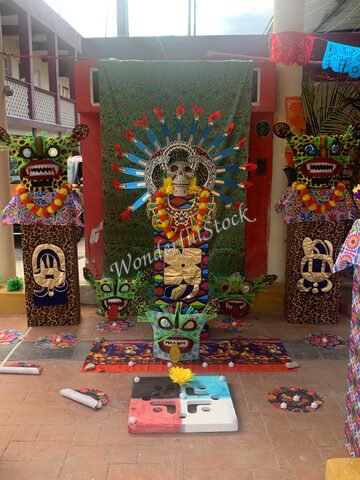 Autel décoré avec des crânes et des motifs colorés à Cancun, Mexique, entouré de fleurs et de décorations traditionnelles.