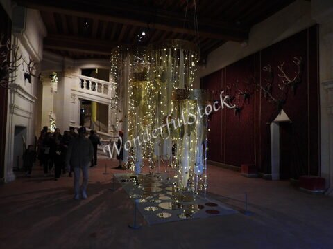 Décorations lumineuses suspendues dans un intérieur avec des têtes de cerf, au château de Chambord, France.