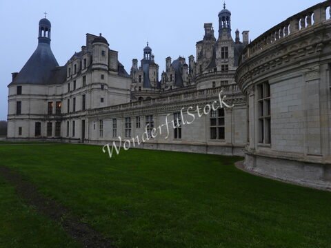 Château de Chambord, France, avec ses toits ornés et ses murs en pierre, entouré d'une pelouse verte.