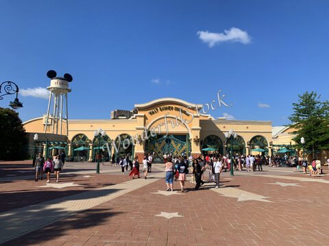 Entrée du parc Walt Disney Studios à France, avec des visiteurs et un ciel bleu.