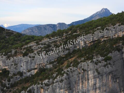 Gorges du Verdon en France, avec des falaises rocheuses et des montagnes en arrière-plan.