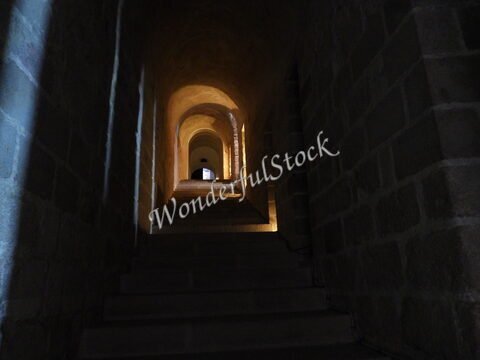 Escalier en pierre menant à une porte dans une structure historique à Mont Saint Michel, France.