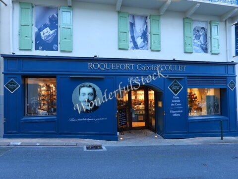 Boutique Roquefort Gabriel Coulet à Roquefort-sur-Soulzon, France, avec une façade bleue et des volets verts, mettant en avant des produits locaux.