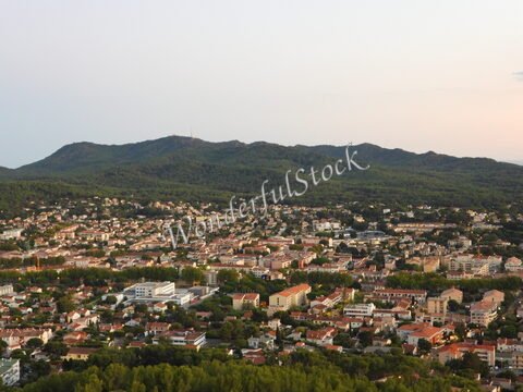 Vue panoramique sur Six-Fours, France, avec des maisons et des collines verdoyantes en arrière-plan.