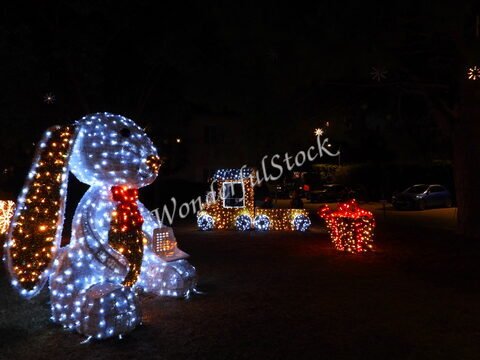 Lapin lumineux et train décoratif à Six-Fours, France, illuminés par des guirlandes dans un décor nocturne.