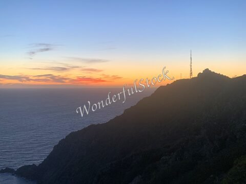 Coucher de soleil sur la mer à Six-Fours, France, avec une silhouette de colline et une antenne sur le sommet.