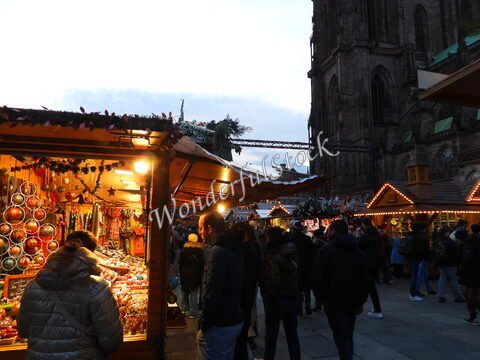 Marché de Noël à Strasbourg, France, avec des stands décorés et la cathédrale en arrière-plan.