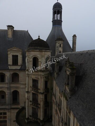 Château à Chambord, France, avec une tour conique et un escalier hélicoïdal visible.